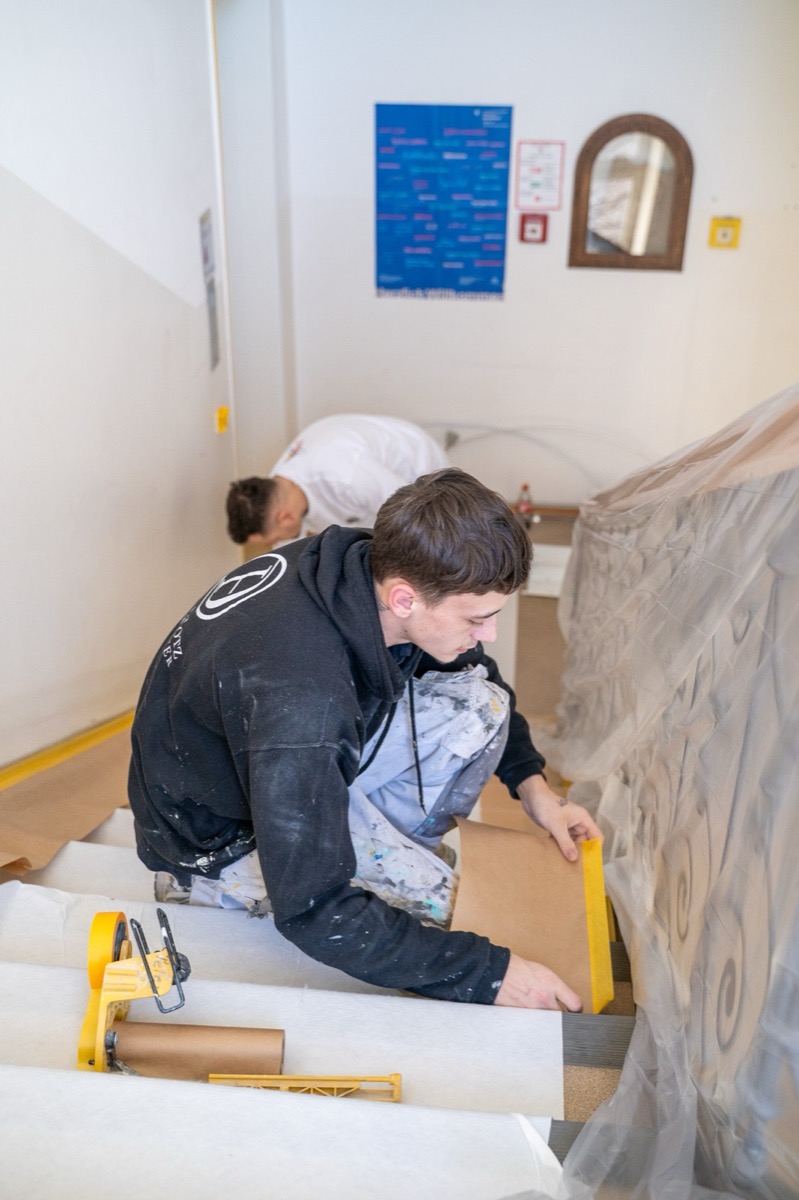 Zwei Maler kleben eine Treppe ab