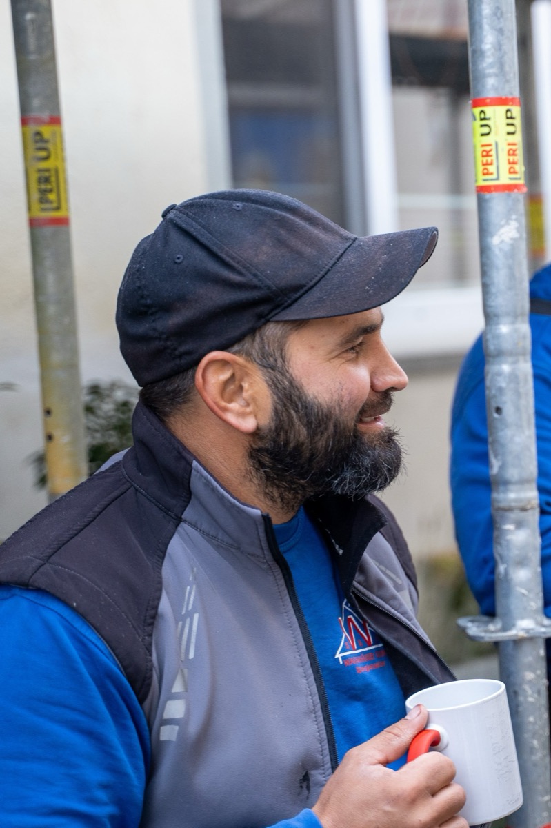 Mitarbeiter mit Kaffeetasse auf dem Gerüst